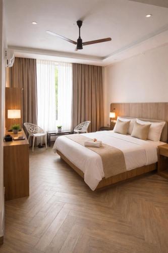 a bedroom with a large bed with a ceiling fan at Vintage Bak Holidays in Vythiri