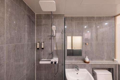 a bathroom with a shower and a toilet and a sink at Marysol Stay in Busan