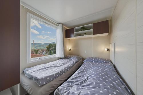 a small bedroom with a bed and a window at NATALiHAUS in Děčín