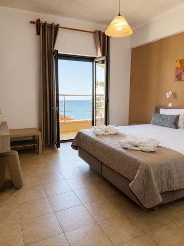 a bedroom with a bed with a view of the ocean at Soula Apartments & Studios in Palaiochora