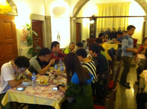 a group of people sitting at tables eating food at Demirkapi Konak Hotel in Safranbolu