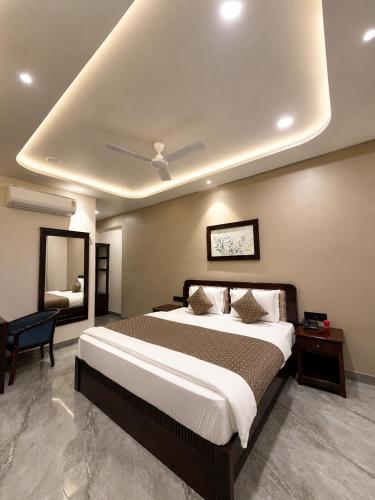 a bedroom with a large bed and a mirror at Grand Valley - A Boutique Resort in Mount Abu in Mount Ābu