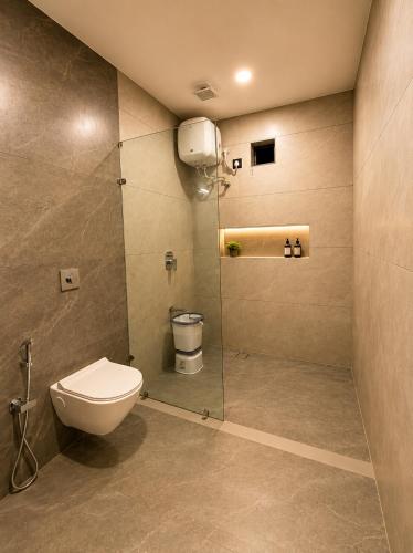a bathroom with a toilet and a glass shower at Grand Valley - A Boutique Resort in Mount Abu in Mount Ābu
