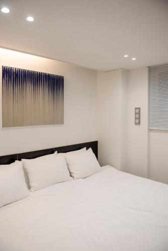 a bedroom with a large white bed with white pillows at 호텔느릿 in Seoul