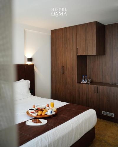 a hotel room with a tray of food on a bed at Qama Hotel in Prishtinë