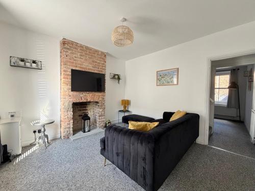 a living room with a couch and a fireplace at Waterloo Street in King's Lynn