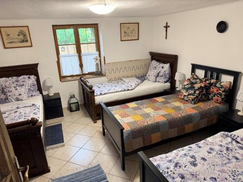 a room with two beds and a cross on the wall at Berkó Vendégház in Rákóczifalva