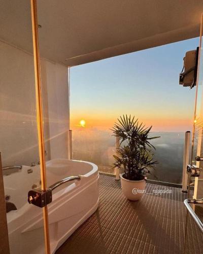 a bathroom with a tub and a window with a plant at A'lanka luxury hotel in haputale in Walhaputenna