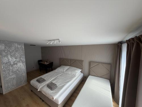 a bedroom with a white bed and a table at Sunrise Apartamenty in Chocicza