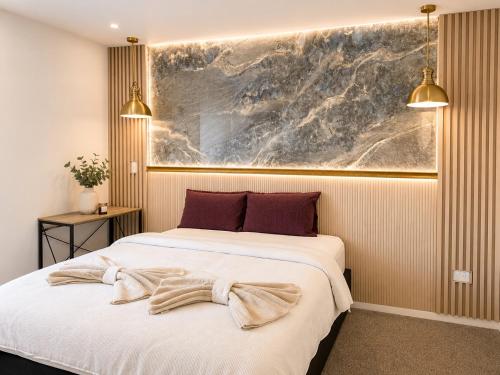 a bedroom with two beds and a painting on the wall at The Gem - 5 bedroom brand new house in Christchurch