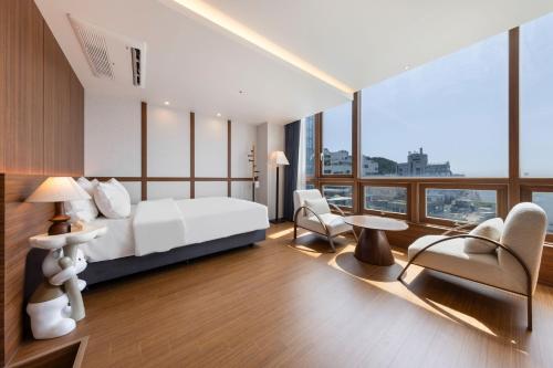 a bedroom with a bed and a table and chairs at Marysol Stay in Busan