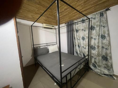 a small bed in a room with a curtain at Villa 4 in Saly Portudal