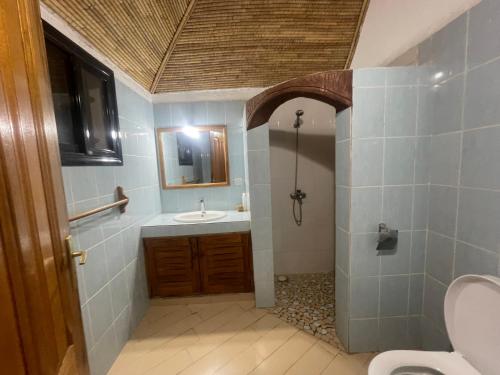 a bathroom with a sink and a toilet and a mirror at Villa 4 in Saly Portudal