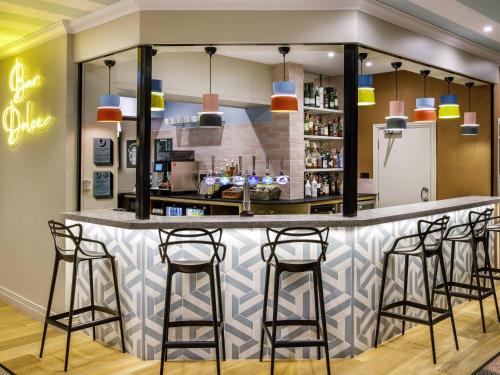 a bar in a restaurant with stools at ibis Styles Bournemouth in Bournemouth