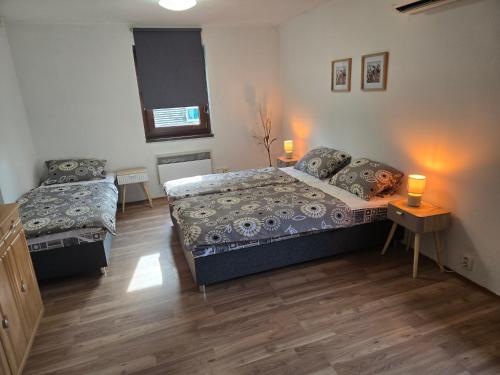 a bedroom with two beds and a table and two lamps at Apartmány Mácháč in Doksy