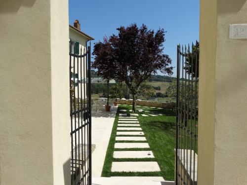 a gate to a garden with grass and a tree at A Family Tale - Una Storia Di Famiglia in Monterchi