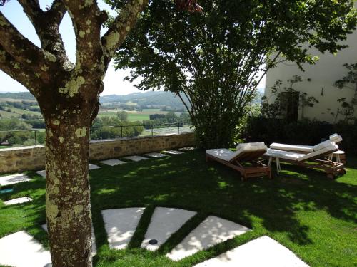 a garden with a tree and a table and chairs at A Family Tale - Una Storia Di Famiglia in Monterchi
