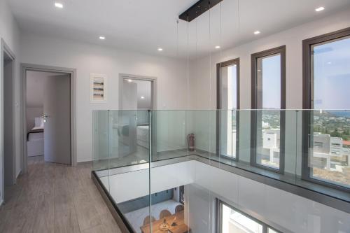 a glass elevator in a white room with windows at Aetheria Luxury Villa in Kalithies
