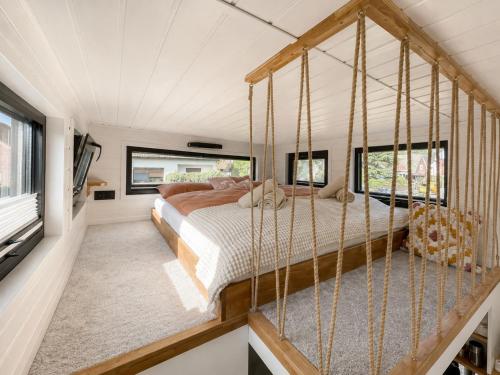 a bedroom with a bed in a room with windows at Tinyhaus Marie von Tinyhaus Steinhude in Steinhude