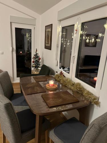 a dining room with a table and a christmas tree at Apt Moravica in Soko Banja