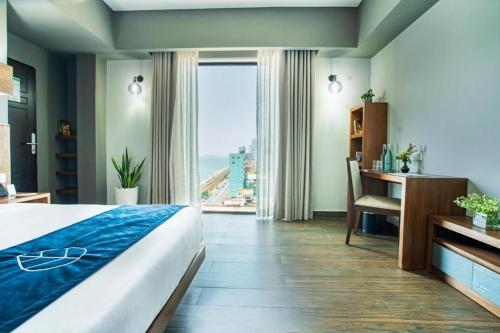 a bedroom with a bed and a desk and a window at A'lanka luxury hotel in haputale in Walhaputenna
