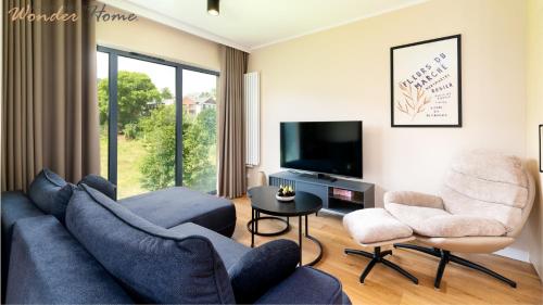 a living room with a blue couch and two chairs at Wonder Home- Izeryn- centrum Świeradowa in Świeradów-Zdrój