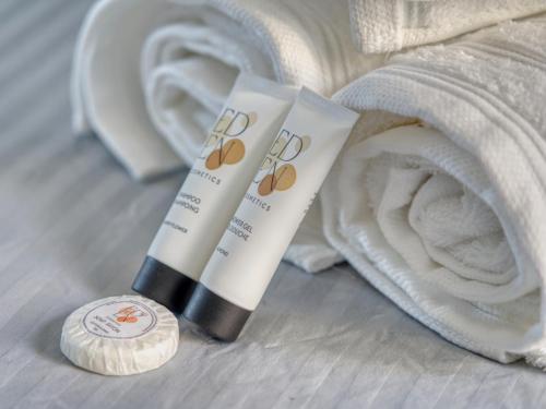 a pair of tube of sunscreen next to a towel at Maison de maître, Piscine privée, 4 suites in Nersac