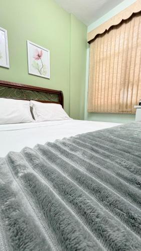 a bedroom with a bed with a gray blanket at Apto Turismo da Serra in Teresópolis