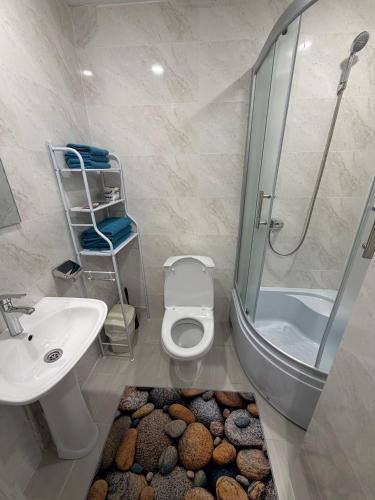 a bathroom with a shower and a toilet and a sink at 7 Nebo in Almaty