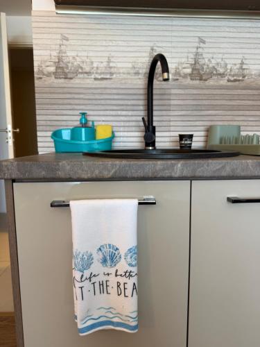 a kitchen counter with a towel that says let the bea at Studio Blaxy Mihnea in Douăzeci şi Trei August