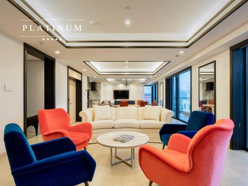 a living room with red and blue chairs and a table at Grand Phenix Hakuba by Jade Villa in Hakuba