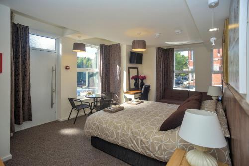 Riverside Hotel في نورويتش: غرفة نوم بسرير وطاولة وكراسي