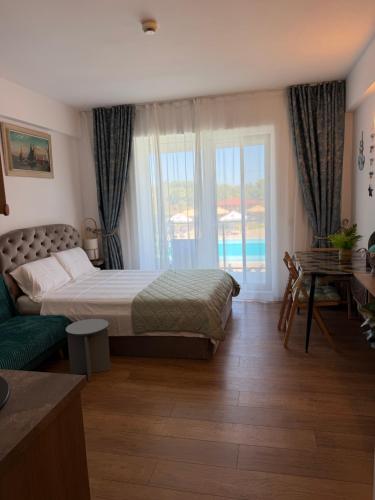 a bedroom with a bed and a large window at Studio Blaxy Mihnea in Douăzeci şi Trei August