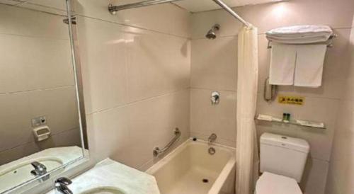 a bathroom with a tub and a sink and a toilet at Macau Masters Hotel in Macau