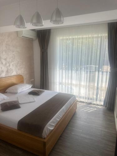 a bedroom with a large bed and a large window at Hotel Victor in Mamaia