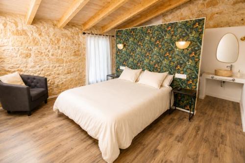 a bedroom with a large bed and a chair at Can Roig in Ses Salines