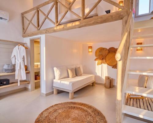 a living room with a white couch and a staircase at Pousada Vina in Jericoacoara