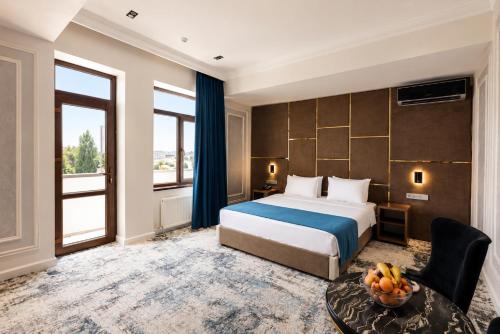 a hotel room with a bed and a large window at Friday Old City Hotel in Tashkent