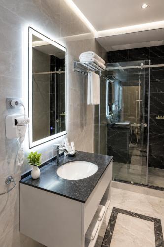 a bathroom with a sink and a glass shower at Friday Old City Hotel in Tashkent