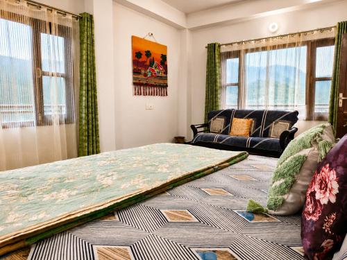a bedroom with a bed and a couch and windows at Whispering Meadows Luxury 3BHK Villa in Shimla