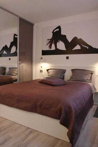 a bedroom with a large bed with a large mirror at Apartment Mala tajna in Rijeka
