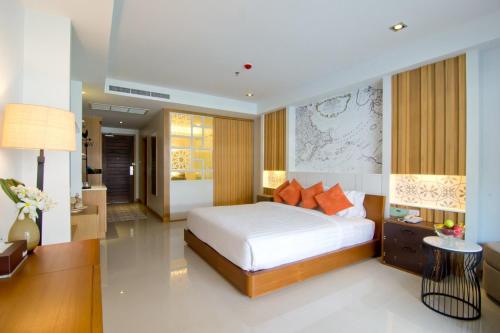 芭達雅南區的住宿－迎世海灘度假酒店及水療中心，一间卧室配有一张床和一张书桌,另一间卧室配有一张桌子。