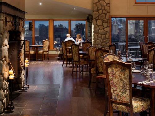 a restaurant with a table and chairs and people sitting at it at Fable Terrace Downs Resort by MGallery in Windwhistle