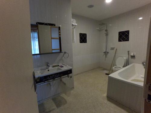 a bathroom with a sink and a tub and a toilet at Ikoro Hotel in Kisoro
