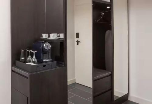 a room with a door to a kitchen with a microwave at Hilton Heidelberg in Heidelberg