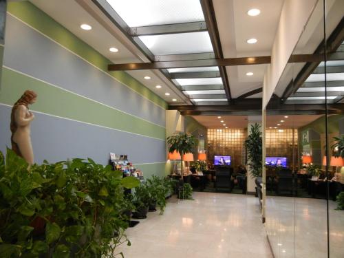 a lobby with potted plants in a hotel at Delle Nazioni Milan Hotel in Milan