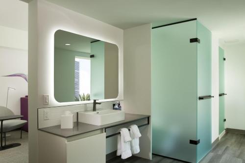 a bathroom with a sink and a mirror at Yotel Miami, Select By Hilton in Miami
