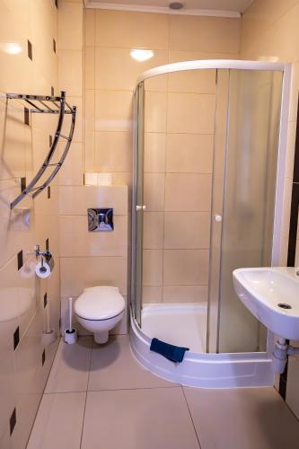 a bathroom with a shower and a toilet and a sink at Dom Weselny Perła Warmii in Lidzbark Warmiński