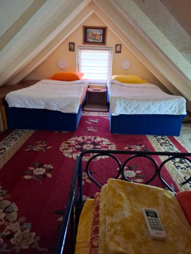a attic room with two beds in a attic at Dukii in Vrnjci