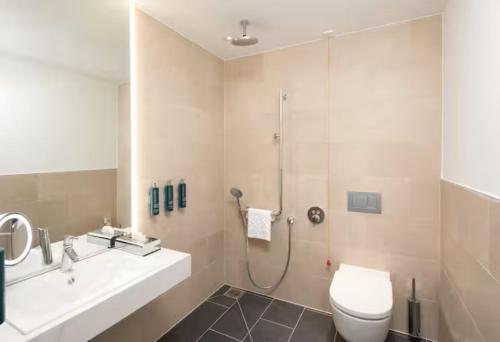 a bathroom with a shower and a toilet and a sink at Hilton Heidelberg in Heidelberg